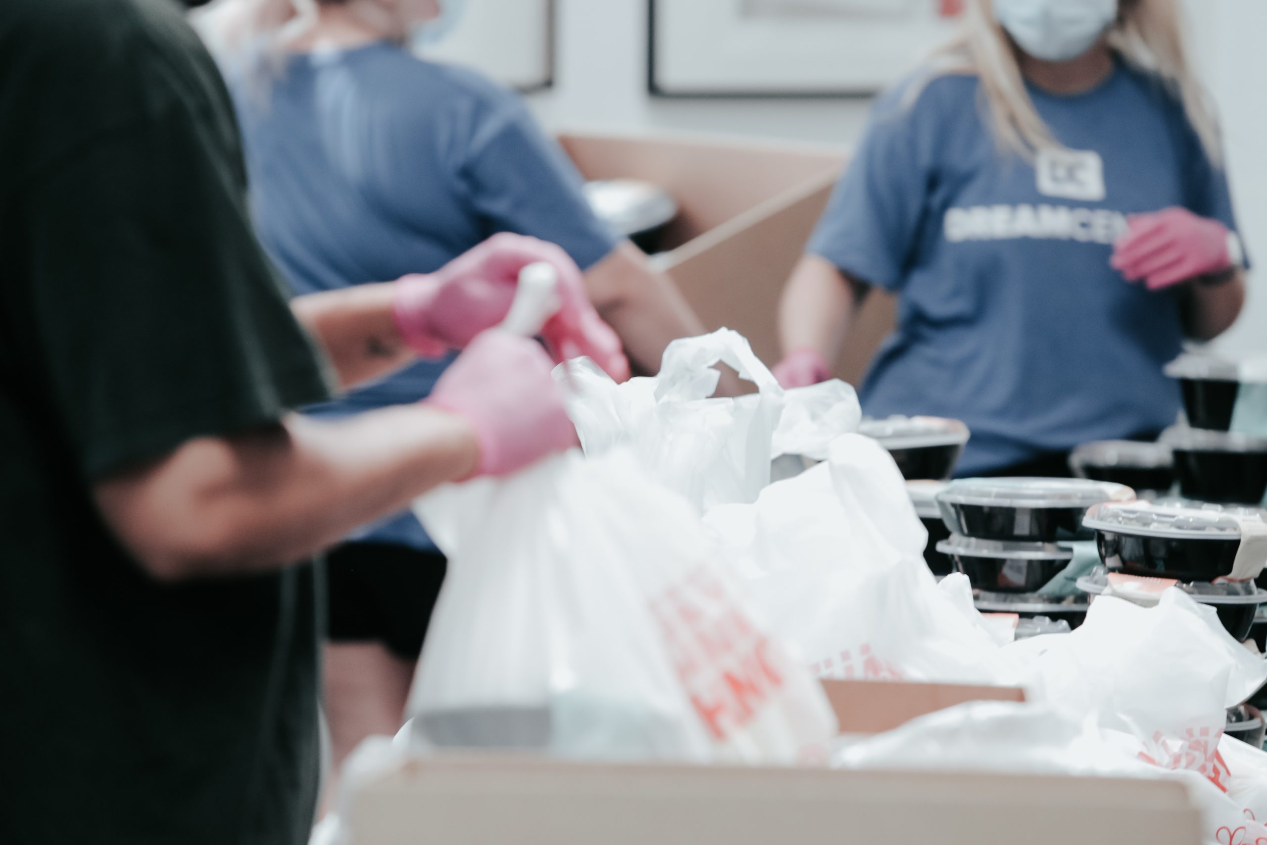 Des bénévoles préparent la distribution des plateaux repas