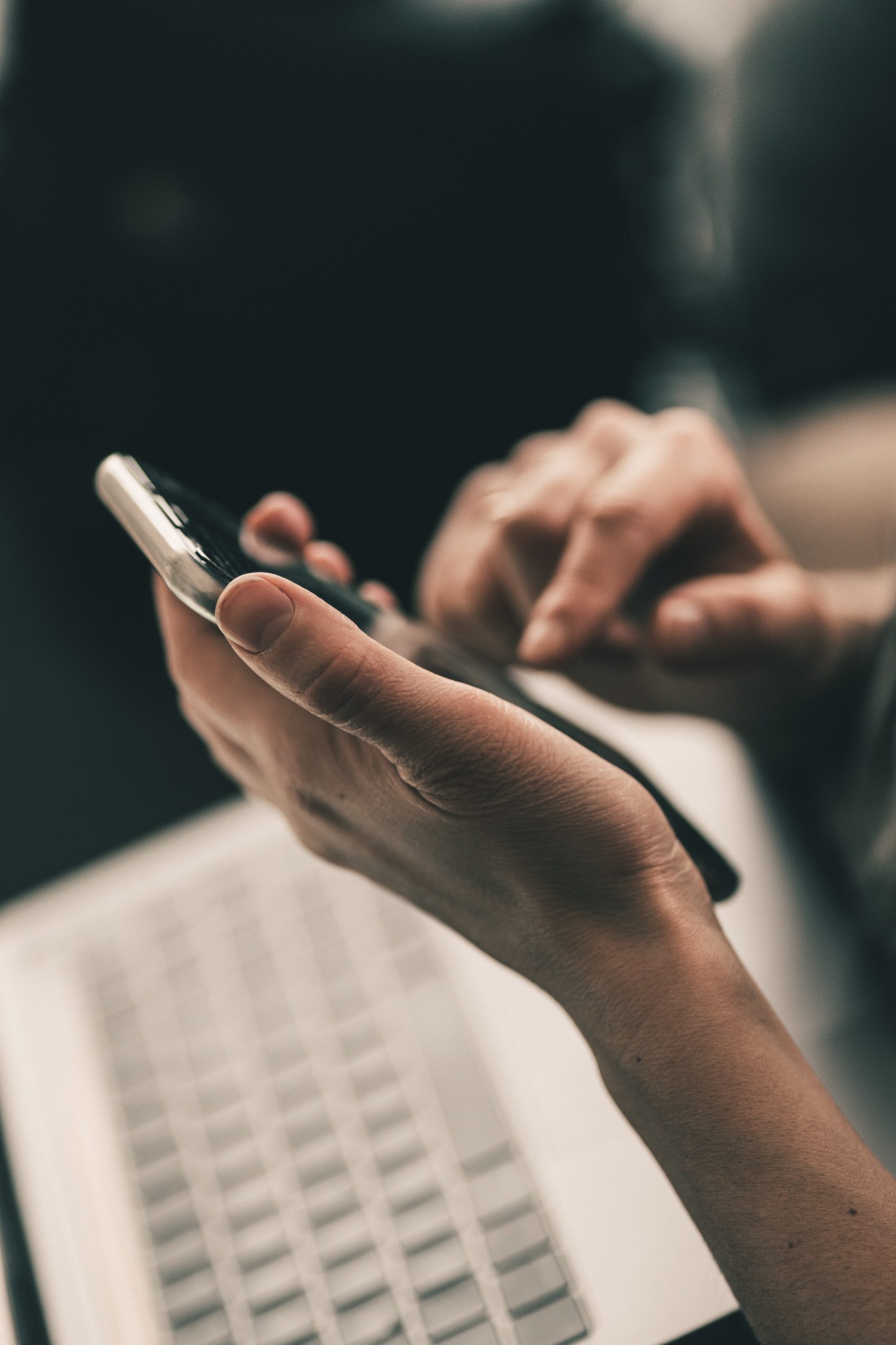 Des mains qui touchent un clavier de portable